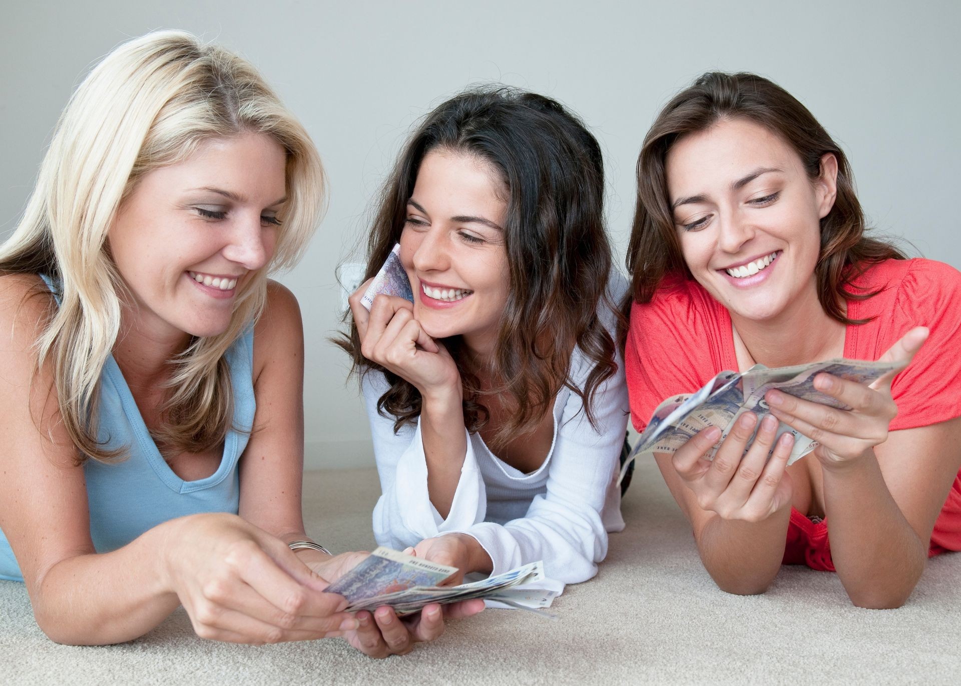 Smiling women counting money together Smiling women counting money together